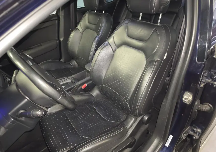 Vue intérieure côté conducteur du DS4 2016 violet montrant les sièges avant en cuir noir perforé et volant cuir.