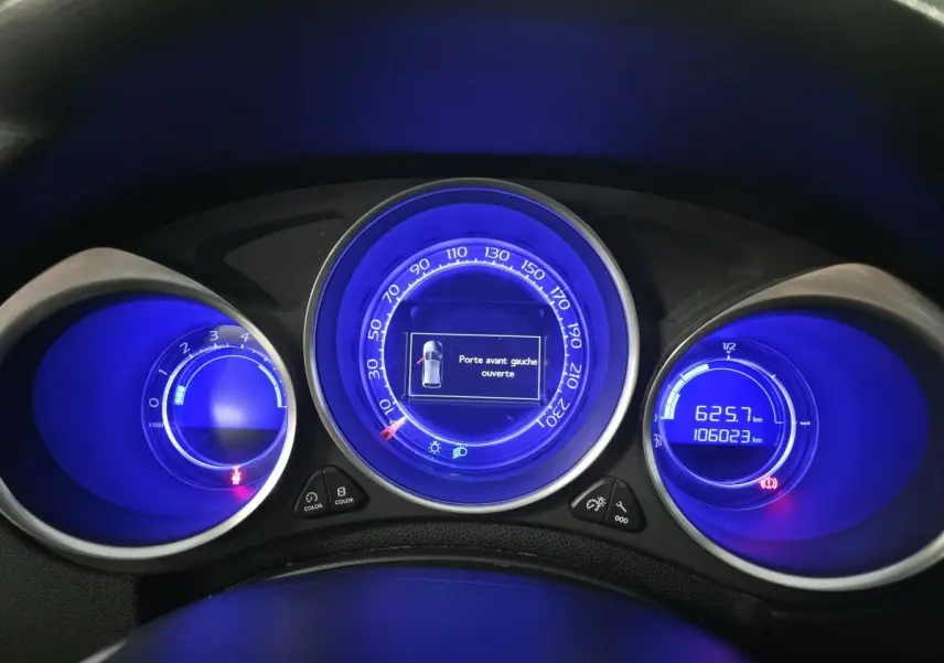 Tableau de bord du DS4 2016 avec combiné à aiguilles et affichage digital bleu, indiquant porte avant gauche ouverte.