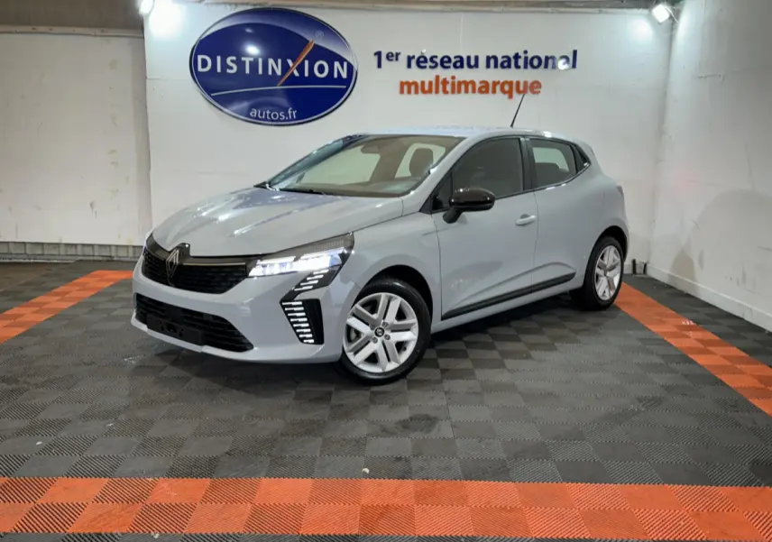 Renault Clio Evolution Blue dCi 100 gris clair vue 3/4 avant droit avec feux LED allumés en showroom.