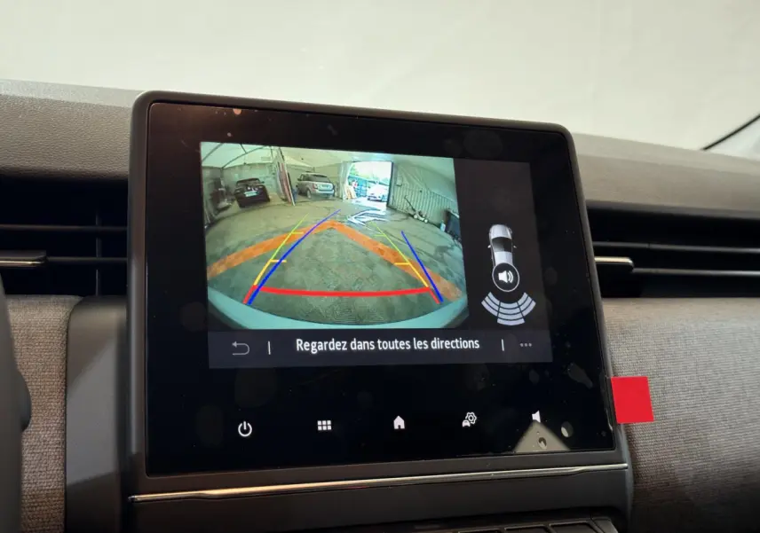 Écran tactile central montrant la caméra de recul avec guidage, intérieur gris clair de la Renault Clio 2025 Evolution Blue dCi.