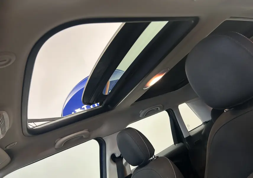 Vue intérieure du toit ouvrant panoramique de la MINI 5 portes Cooper D bleu, avec sièges avant en tissu noir.