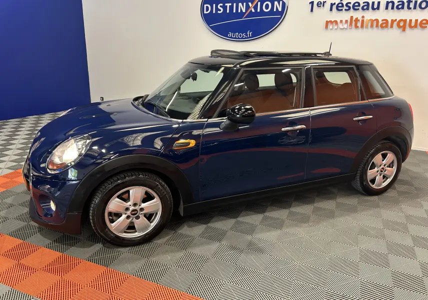 Vue côté gauche en 3/4 avant d'une MINI 5 portes Cooper D bleu avec toit ouvrant et intérieur cuir marron.