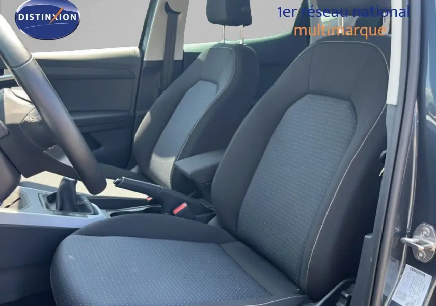 Vue intérieure côté droit sur les sièges tissu gris clair et noir du SEAT Arona 2025 avec levier de vitesse manuel visible.