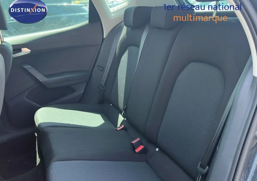 Vue intérieure de la banquette arrière côté droit d’un SEAT Arona gris avec sellerie tissu noir à motifs discrets.