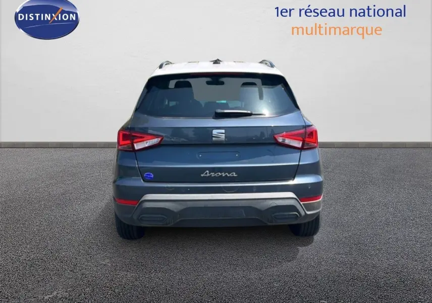 Vue arrière d'un SEAT Arona gris Magnetic avec toit blanc, montrant les feux arrière et le logo central.