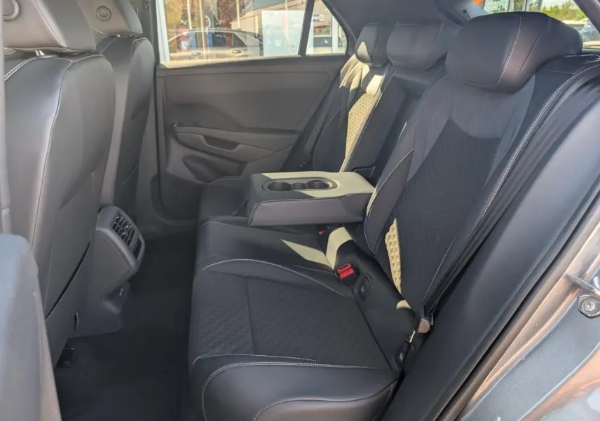 Vue latérale droite de la banquette arrière noire avec accoudoir central rabattable du Volkswagen T-Roc gris 2026 R-Line.