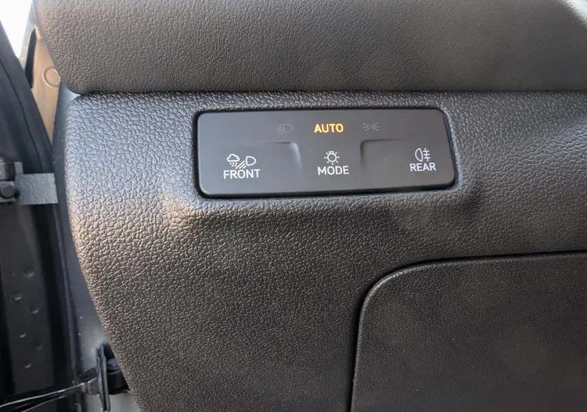 Gros plan sur le tableau de bord noir du Volkswagen T-Roc 2026 montrant les commandes d'éclairage automatiques.