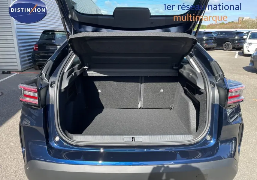Coffre ouvert vu de l'arrière d'une Citroën C4 Hybrid 145ch bleu eclipse métal, avec hayon relevé en extérieur.