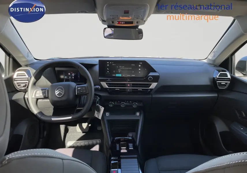 Vue intérieure avant du Citroën C4 Hybrid 145ch avec tableau de bord noir et écran tactile central lumineux.