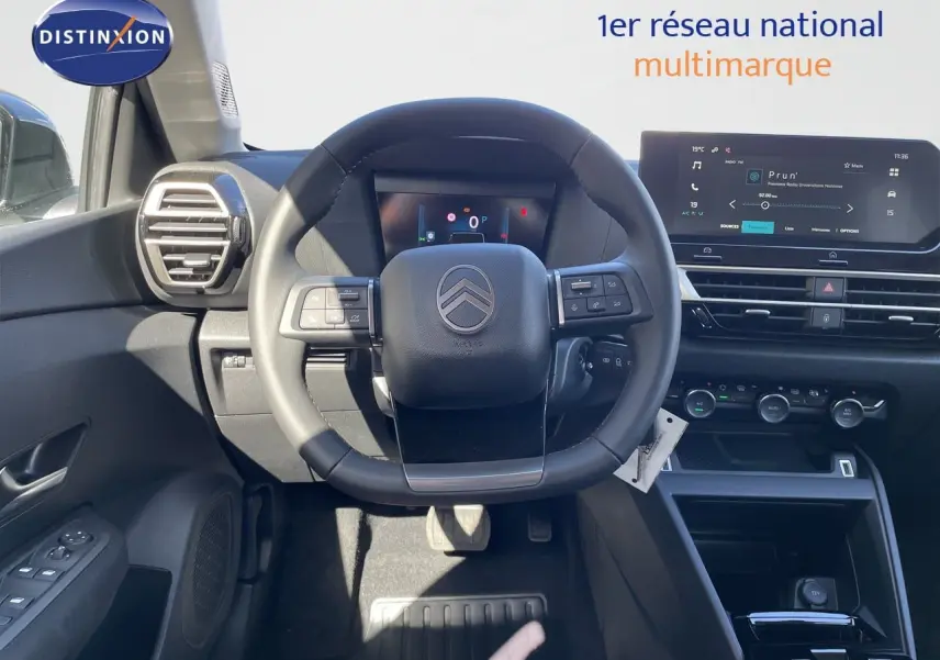 Vue intérieure centrée sur le volant Citroën C4 Hybrid 2026, avec tableau de bord numérique et écran tactile moderne.