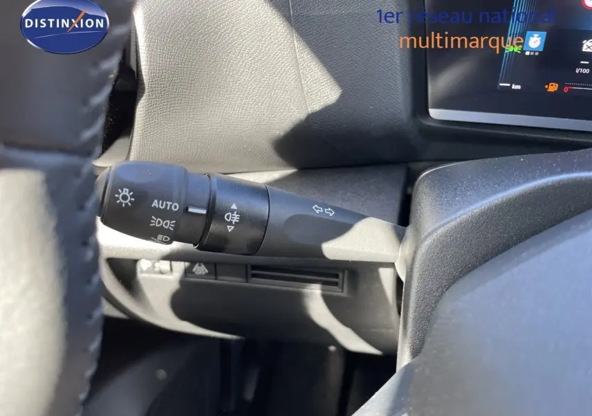 Gros plan sur la commande des feux et clignotants à gauche du volant d’une Citroën C4 hybride 2026.