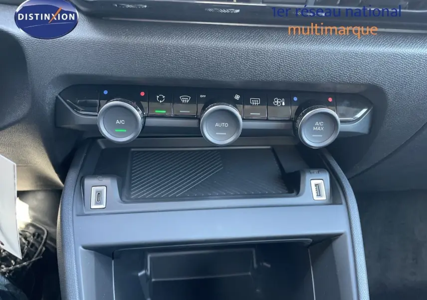 Vue rapprochée de la console centrale avec commandes de climatisation et ports USB d’une Citroën C4 hybride.