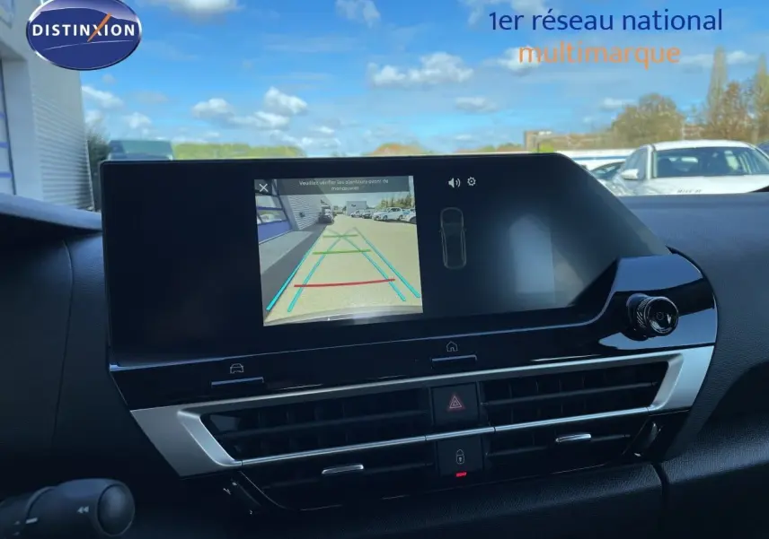 Écran central de la Citroën C4 Hybrid 145ch bleu Eclipse Metal montrant la caméra de recul et la console noire brillante.