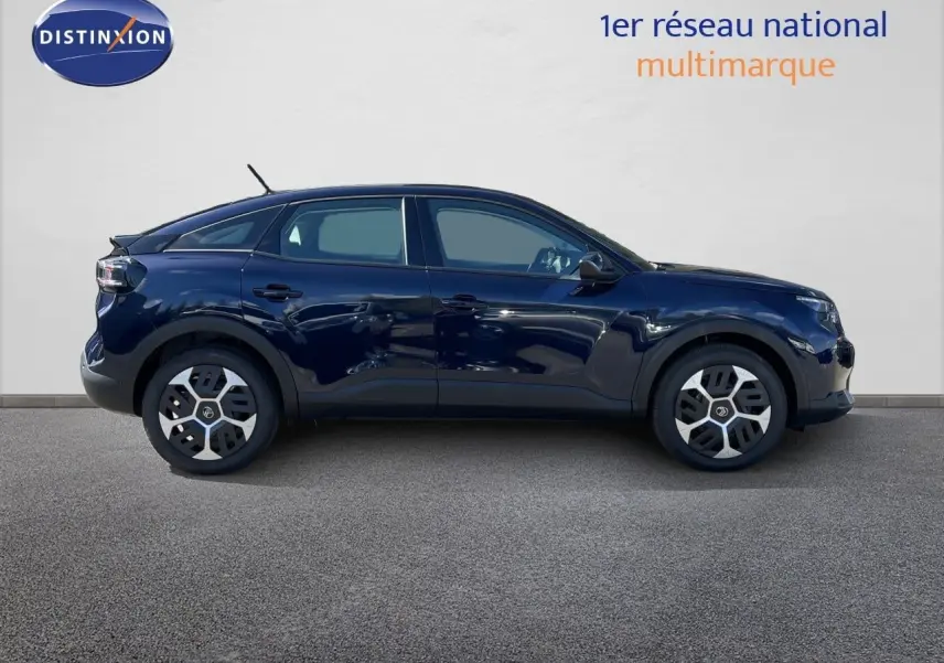 Profil droit d'une Citroën C4 Hybrid 145ch bleu éclipse métal avec jantes distinctives, sur fond neutre intérieur showroom.
