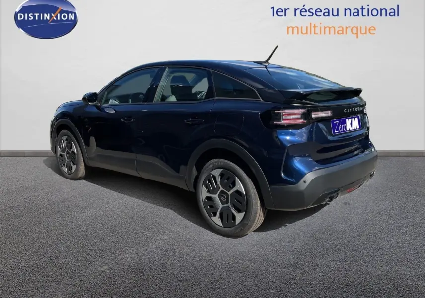 Vue 3/4 arrière droite d'une Citroën C4 hybride bleu eclipse metal avec jantes spécifiques et toit noir.