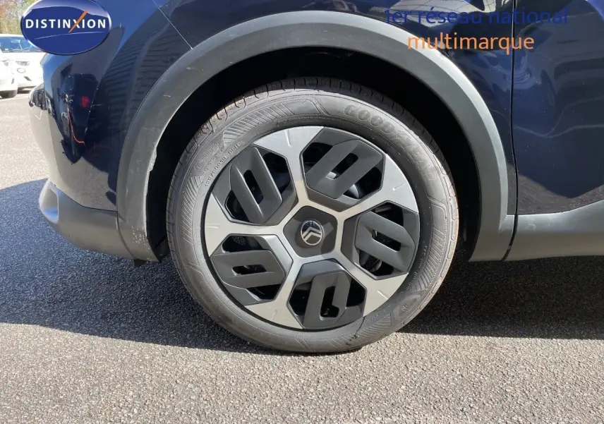 Gros plan sur la roue avant droite d'une Citroën C4 bleu eclipse métal avec jante au design géométrique.
