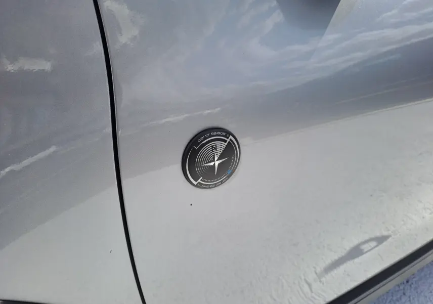 Gros plan sur l'écusson noir et argenté sur la porte côté gauche d'un Peugeot 2008 gris 2019.