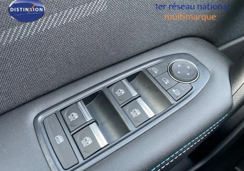 Gros plan sur les commandes électriques des vitres et rétroviseurs sur la porte côté gauche d'une Renault Symbioz gris rafale.