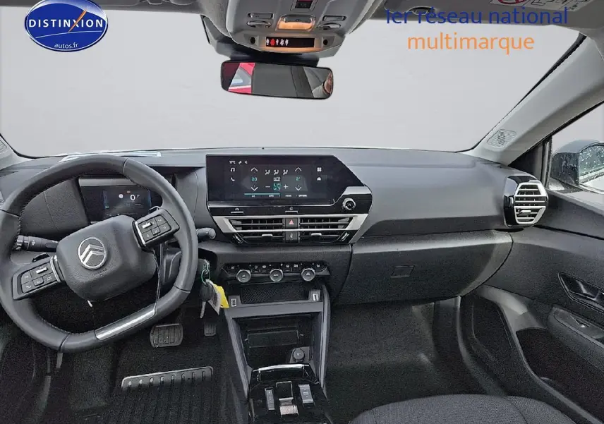Intérieur noir du Citroën C4 1.2 hybride 136 plus 2025 vu de face, avec écran tactile et volant multifonction.