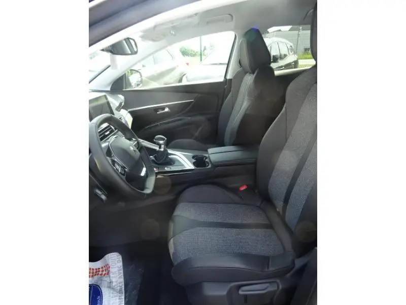Intérieur avant droit du Peugeot 3008 gris clair 2019, sièges tissu et cuir, volant multifonction et boîte manuelle visible.