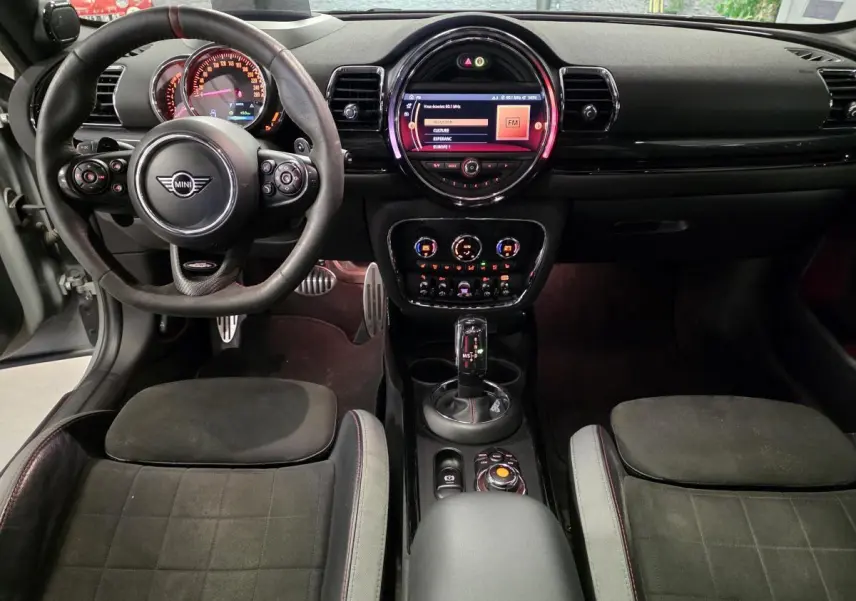 Vue intérieure avant de la MINI Clubman John Cooper Works 2020, sièges sport noirs et tableau de bord avec écran central lumineux.