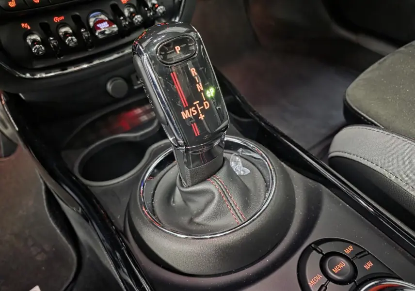 Le levier de vitesses automatique noir avec surpiqûres rouges dans l'habitacle d'une MINI Clubman John Cooper Works.
