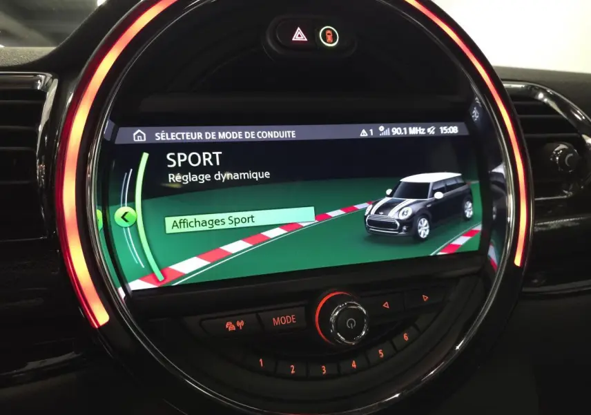 Écran central rond MINI Clubman 2020 affichant le mode de conduite Sport avec éclairage LED orange autour.