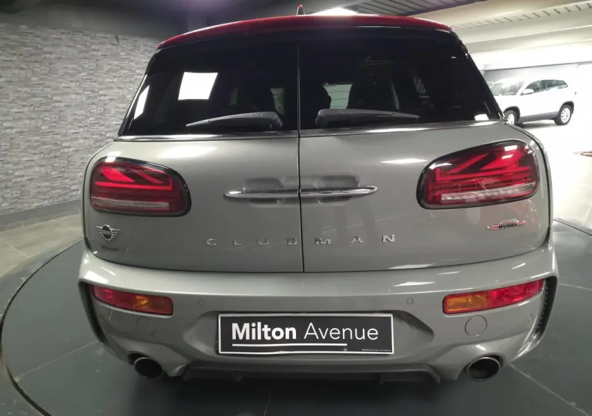 Vue arrière d'une MINI Clubman John Cooper Works gris métallisé avec double sortie d'échappement et feux LED distinctifs.