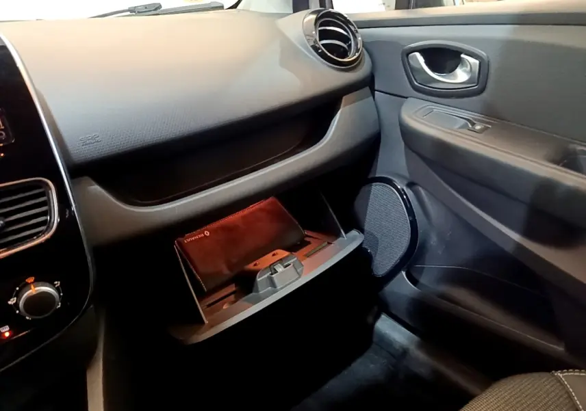 Intérieur côté passager de la Renault Clio Zen Energy dCi 75 2016, boîte à gants ouverte avec pochette Renault visible.