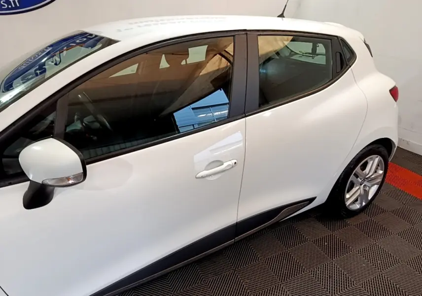 Vue latérale droite d'une Renault Clio Zen Energy dCi 75 blanche avec rétroviseur et jantes visibles.