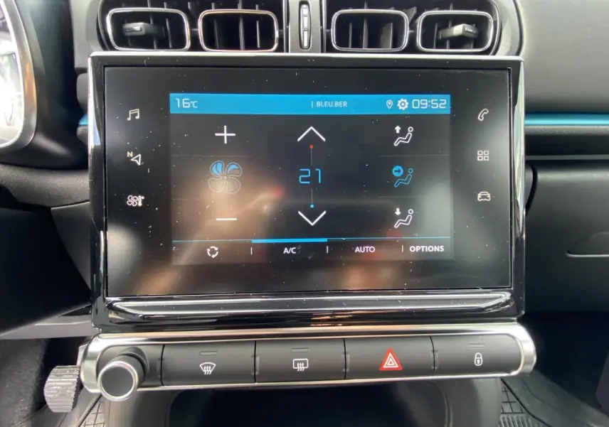 Écran tactile central du tableau de bord de la Citroën C3 noire, affichant les réglages de climatisation à 21°C.
