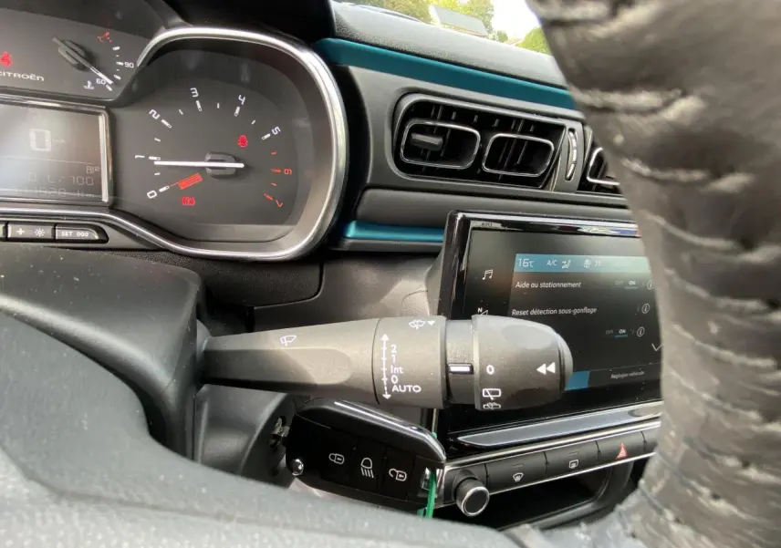 Vue rapprochée du tableau de bord et volant noir d'une Citroën C3 2021, avec écran tactile et commandes au volant visibles.