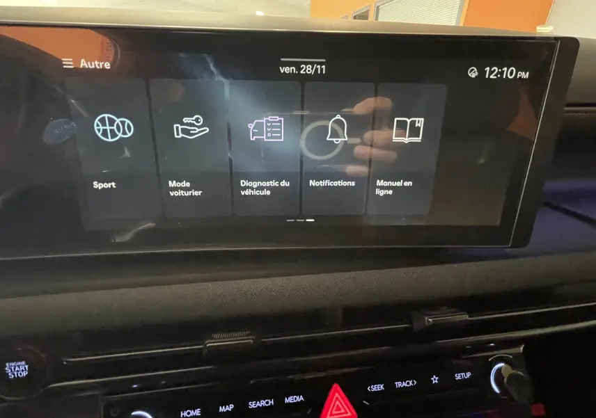 Écran tactile central du Hyundai Tucson 2025 affichant les options Sport, Mode voiturier, Diagnostic, Notifications et Manuel en ligne.