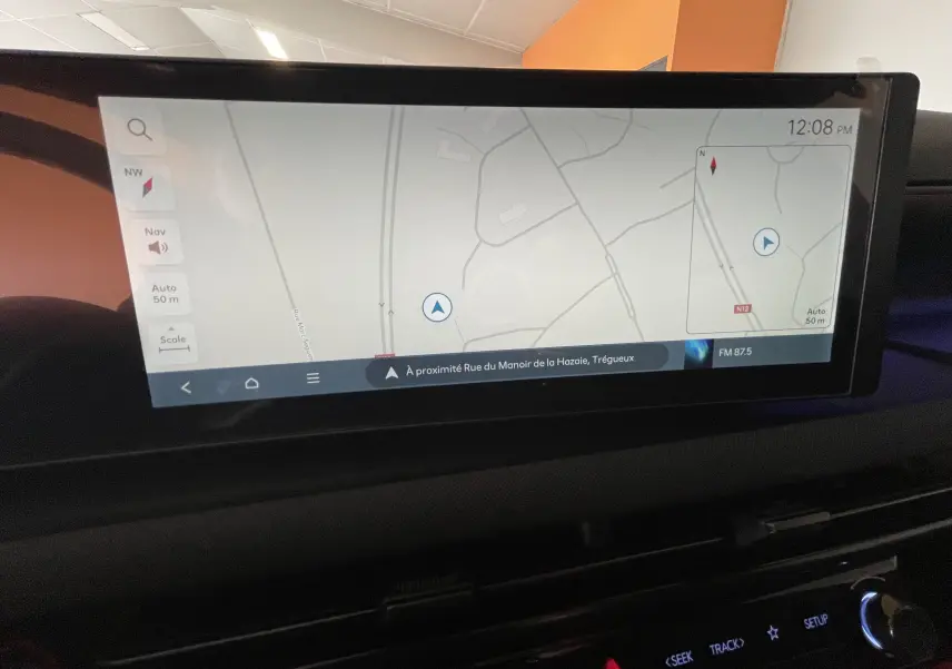Écran tactile du système de navigation du Hyundai Tucson 2025 affichant une carte avec itinéraire, intérieur sombre.