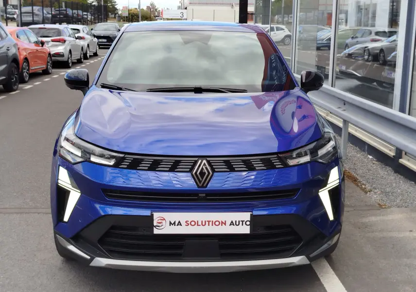 Vue frontale d'une Renault Symbioz bleu iron metal avec feux LED allumés et calandre noire brillante.