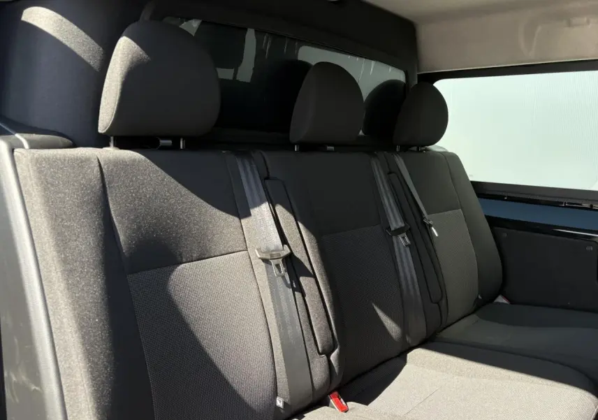 Vue intérieure de la banquette arrière grise du Citroën Jumpy noir Perla, avec ceintures et vitres latérales teintées.