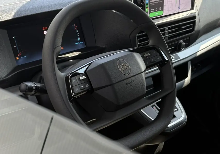 Gros plan sur le volant multifonction noir du Citroën Jumpy 2026 avec tableau de bord numérique et écran tactile intégré.