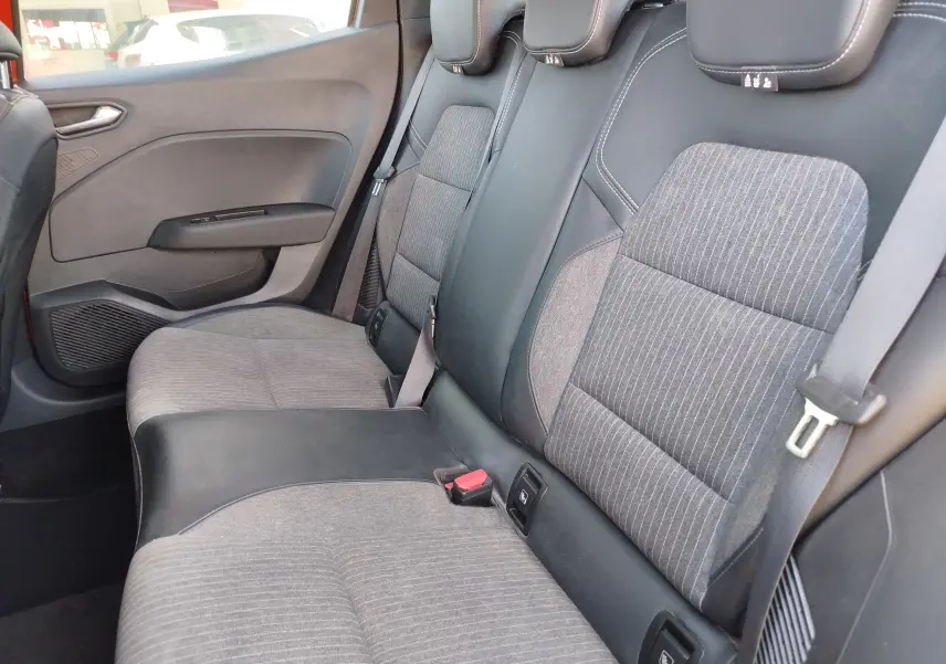 Vue intérieure côté droit des sièges arrière gris et noir de la Renault Clio 1.6 E-Tech hybride 2022, avec ceintures et appuie-têtes.