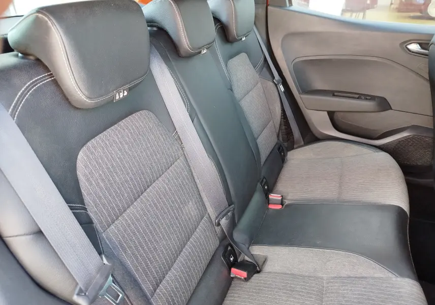 Vue latérale intérieure montrant la banquette arrière gris foncé et noir de la Renault Clio Intens 2022.