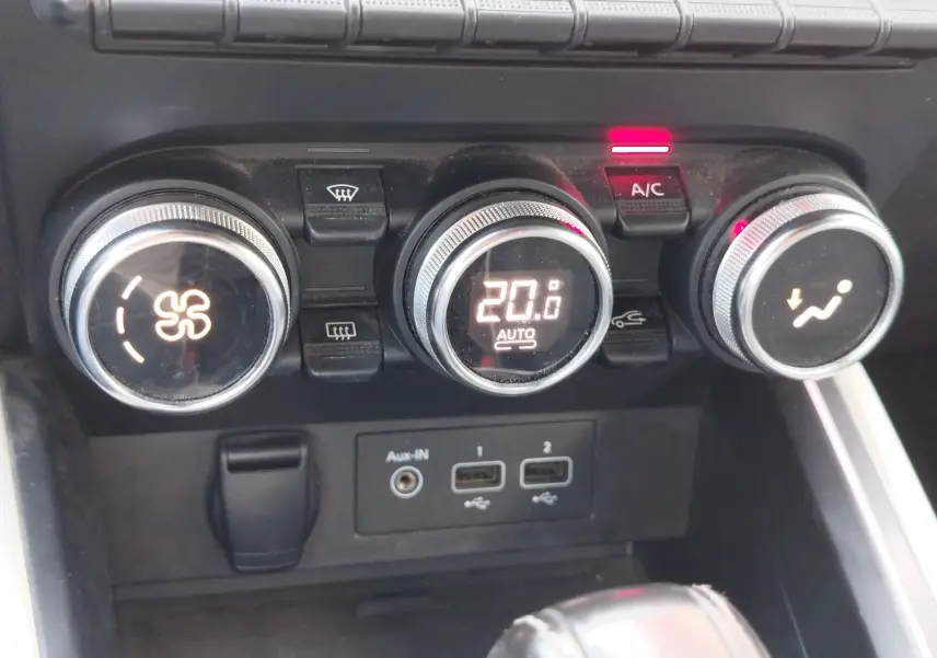 Gros plan sur les commandes de climatisation automatique de la Renault Clio 1.6 E-Tech, avec affichage digital à 20°C.