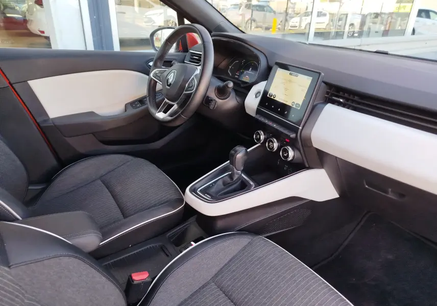 Vue intérieure côté conducteur de la Renault Clio 1.6 E-Tech hybride 2022, avec tableau de bord moderne et sellerie noire.