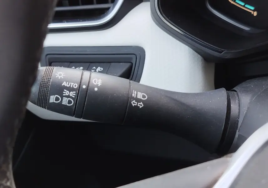 Gros plan sur la commande des phares et clignotants à gauche du volant dans l’habitacle de la Renault Clio orange Valencia.