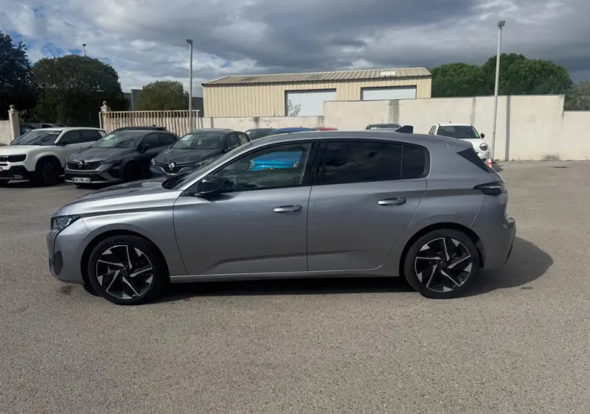 Peugeot 308 Hybrid gris vue de profil côté gauche, avec jantes alliage noires et vitres teintées.
