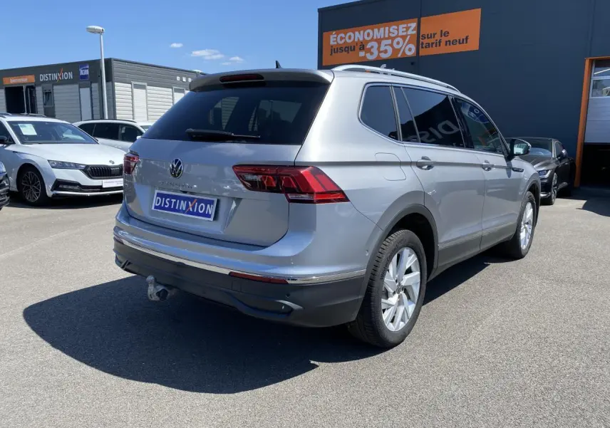Volkswagen Tiguan Allspace gris argent pyrite métallisé vu en 3/4 arrière droit avec crochet d'attelage escamotable.