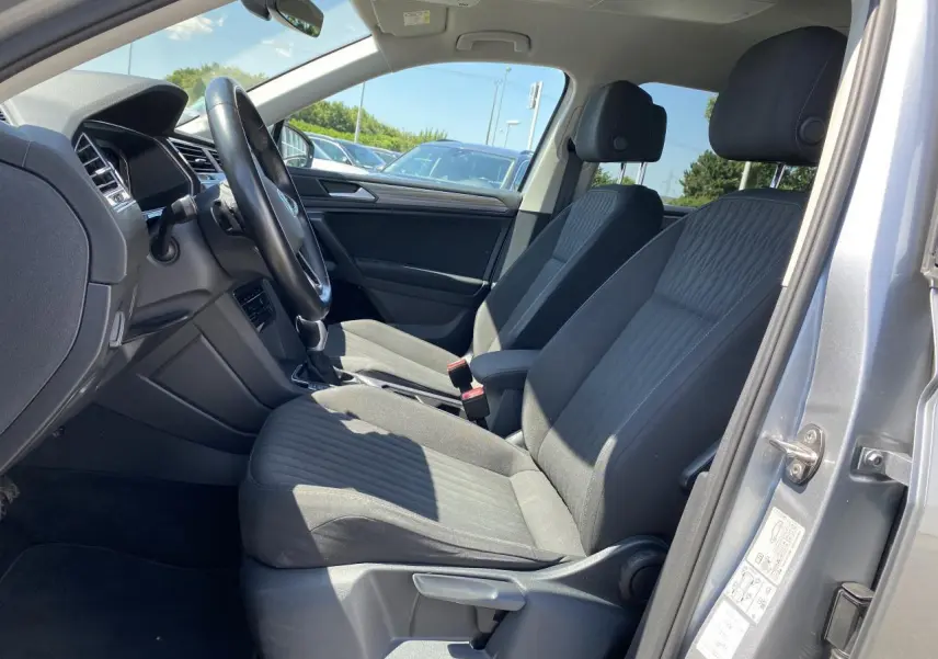 Vue intérieure côté conducteur du Volkswagen Tiguan Allspace 2022 gris argent avec sellerie tissu Life noire.