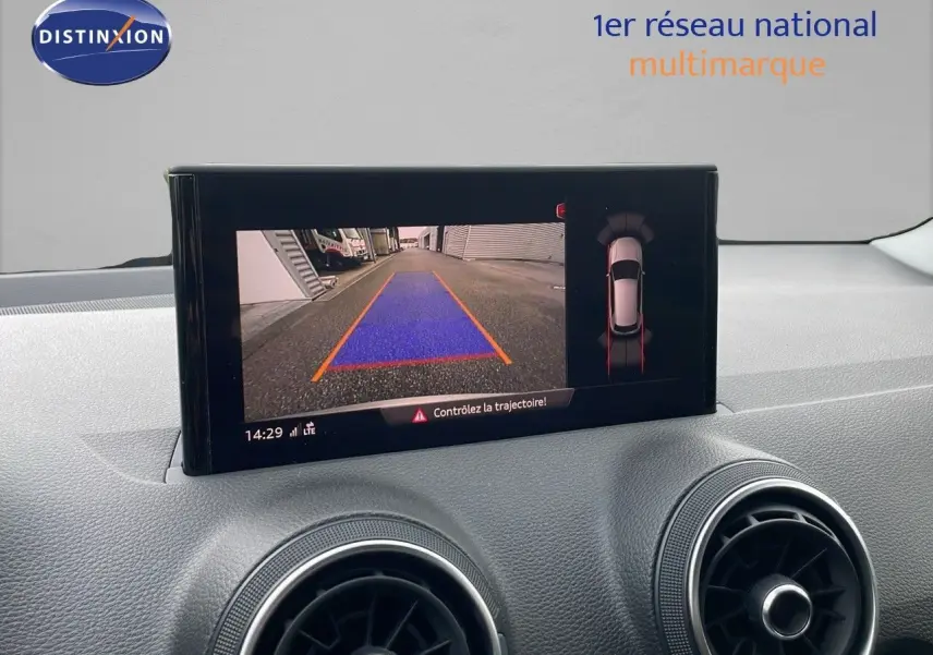 Écran central affichant la caméra de recul et l'aide au stationnement de l'Audi Q2 noir mito metal, vue intérieure du tableau de bord.