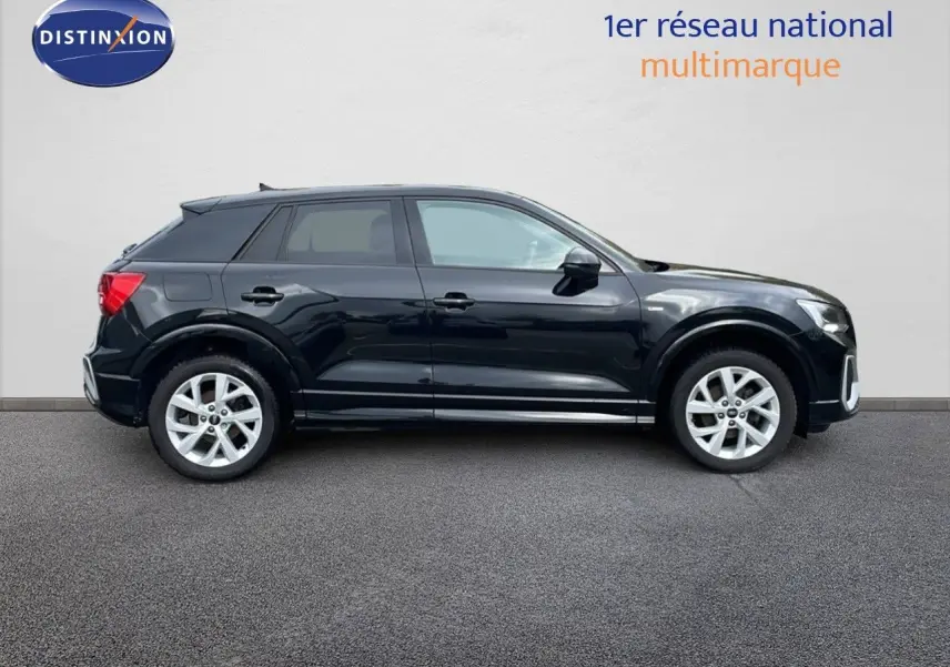Profil côté gauche d'un Audi Q2 35 TFSI S-Line noir mito metal, avec jantes argentées et lignes dynamiques.