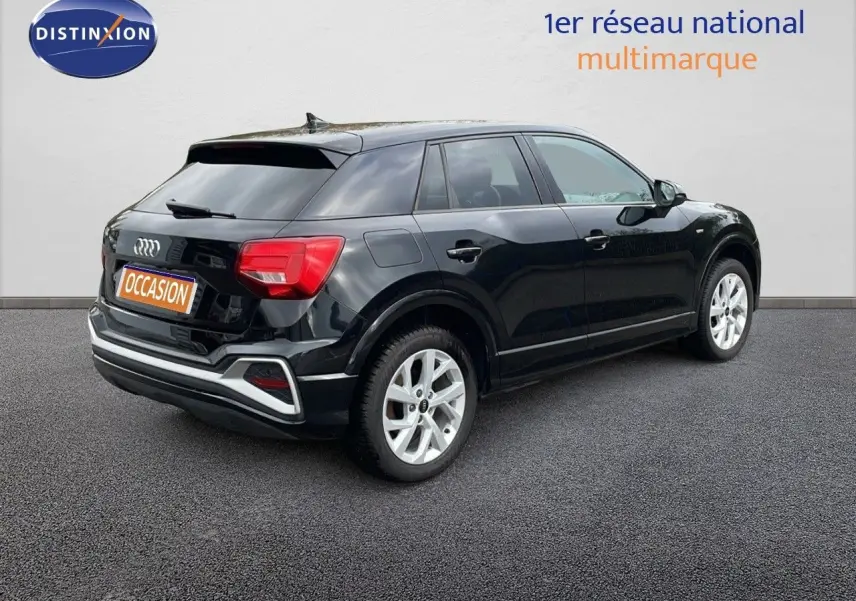 Audi Q2 noir mito metal vue 3/4 arrière côté droit, avec jantes argentées et feux arrière rouges visibles.