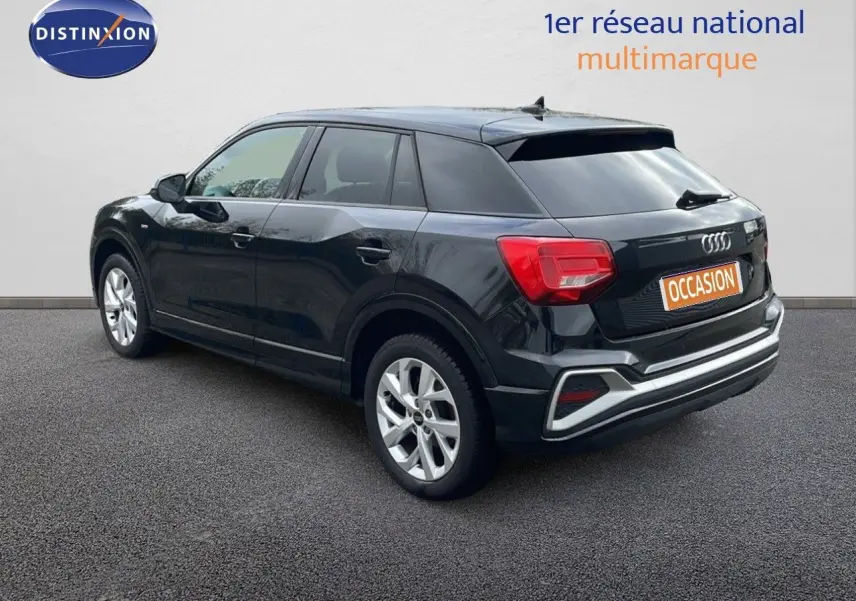 Audi Q2 noir mito metal en 3/4 arrière droit, soulignant ses feux arrière rouges et ses jantes argentées.