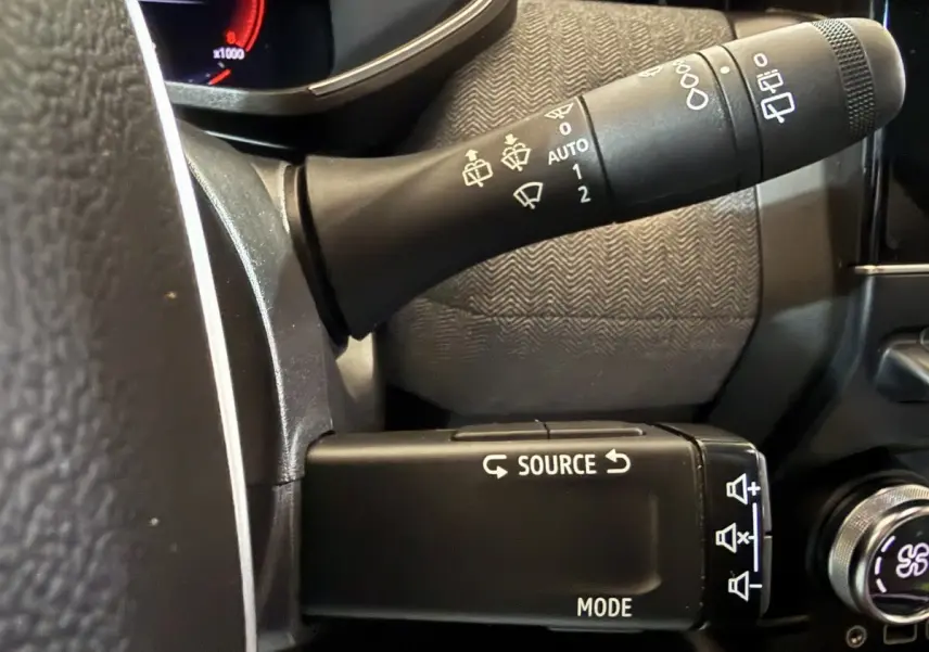 Gros plan sur les commandes au volant à gauche de la Renault Clio Techno TCe 90 2024, avec boutons source et mode.
